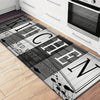 A rectangular kitchen mat with distressed wood texture and black lettering that reads Kitchen Seasoned with Love