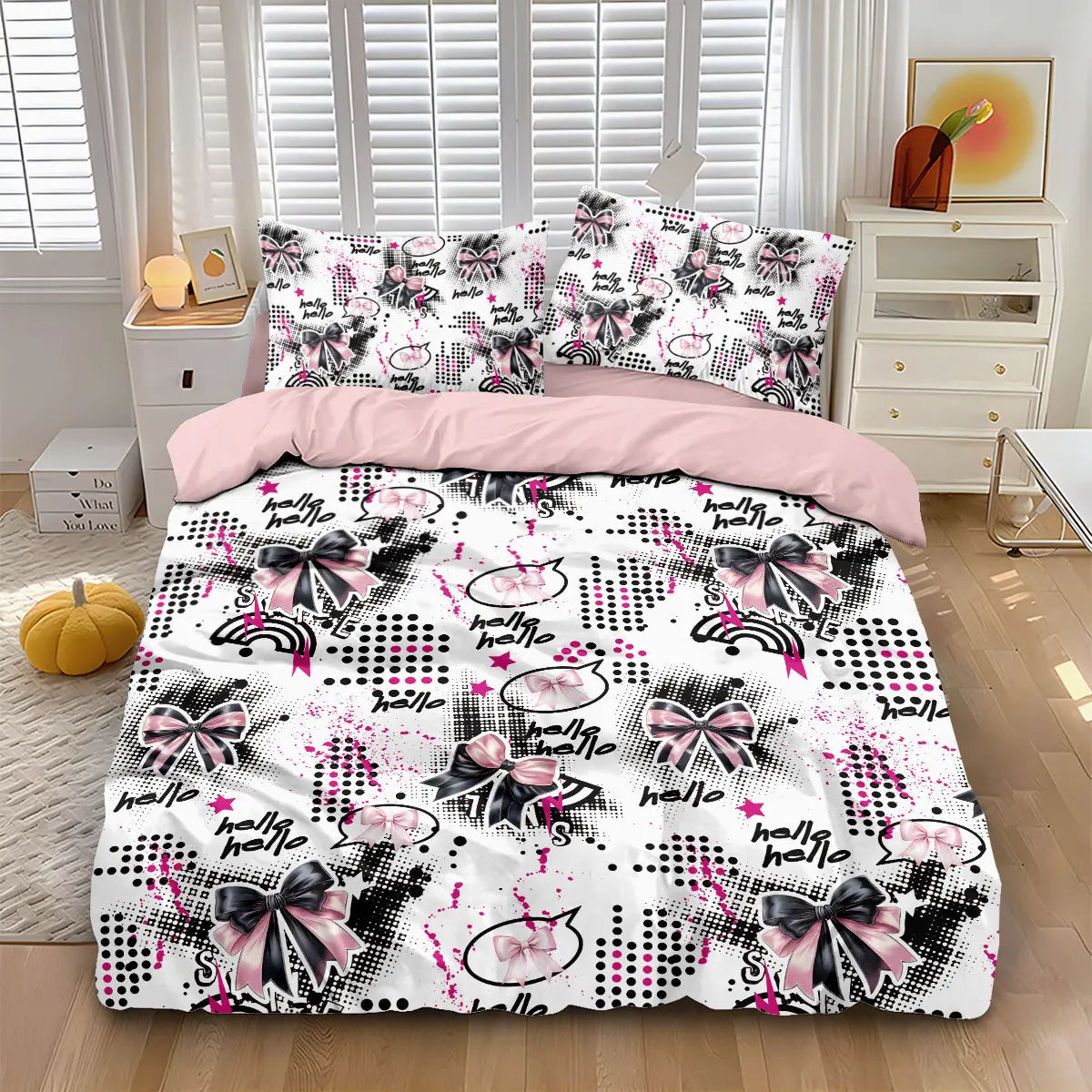 A pink bow printed duvet cover set featuring black and pink patterns displayed on a bed.