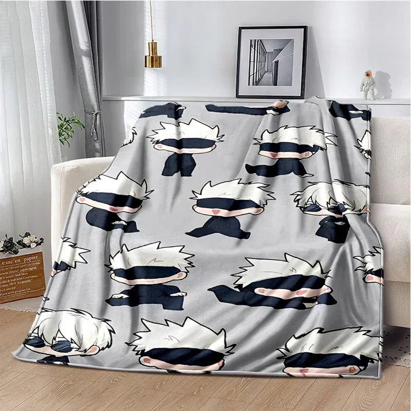A gray throw blanket featuring a repeating pattern of Jujutsu Kaisen anime characters with white and dark blue hair.