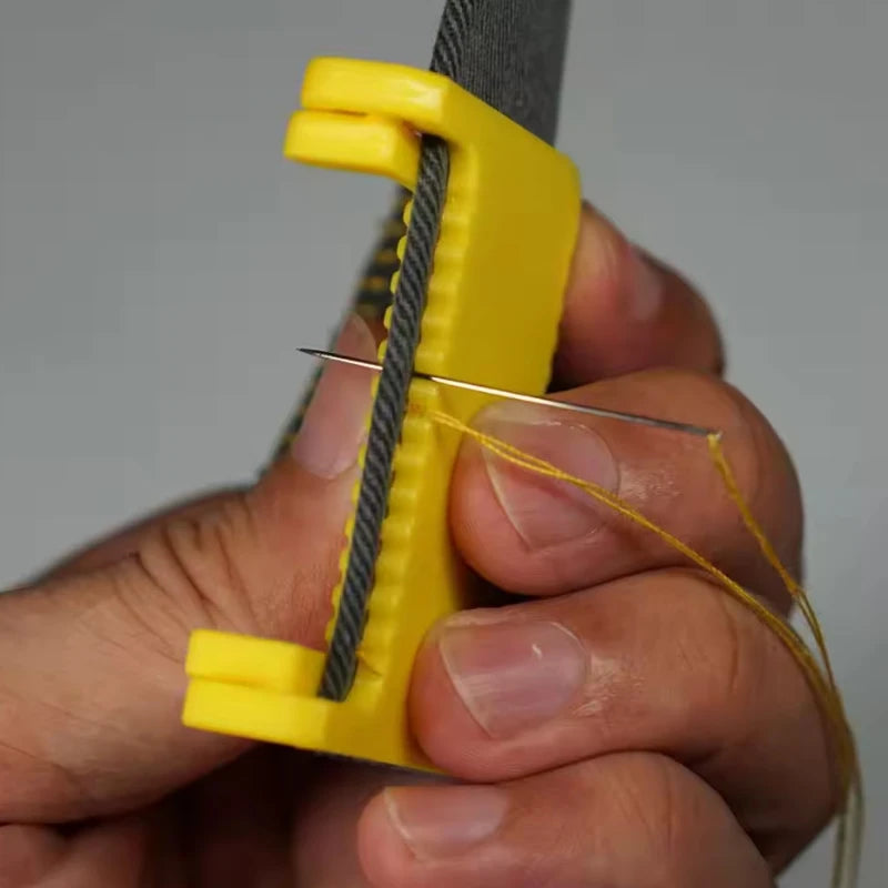 A hand holds a yellow hinge-type fabric sewing guide with a measuring scale and a yellow thread.
