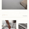 A light gray stretchy polar fleece sofa cover draped over a modern sectional sofa.