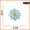 A single light blue embroidered flower patch with a yellow center, shown against a white background.