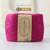 A skein of magenta bamboo fiber yarn labeled as dark pink, used for crafting.