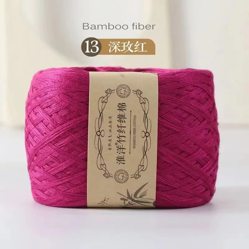A skein of magenta bamboo fiber yarn labeled as dark pink, used for crafting.