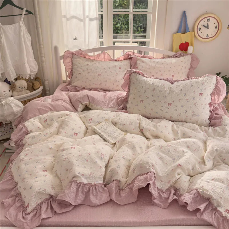 Pink and white princess style ruffle bedding set with pillows and a duvet on a bed.