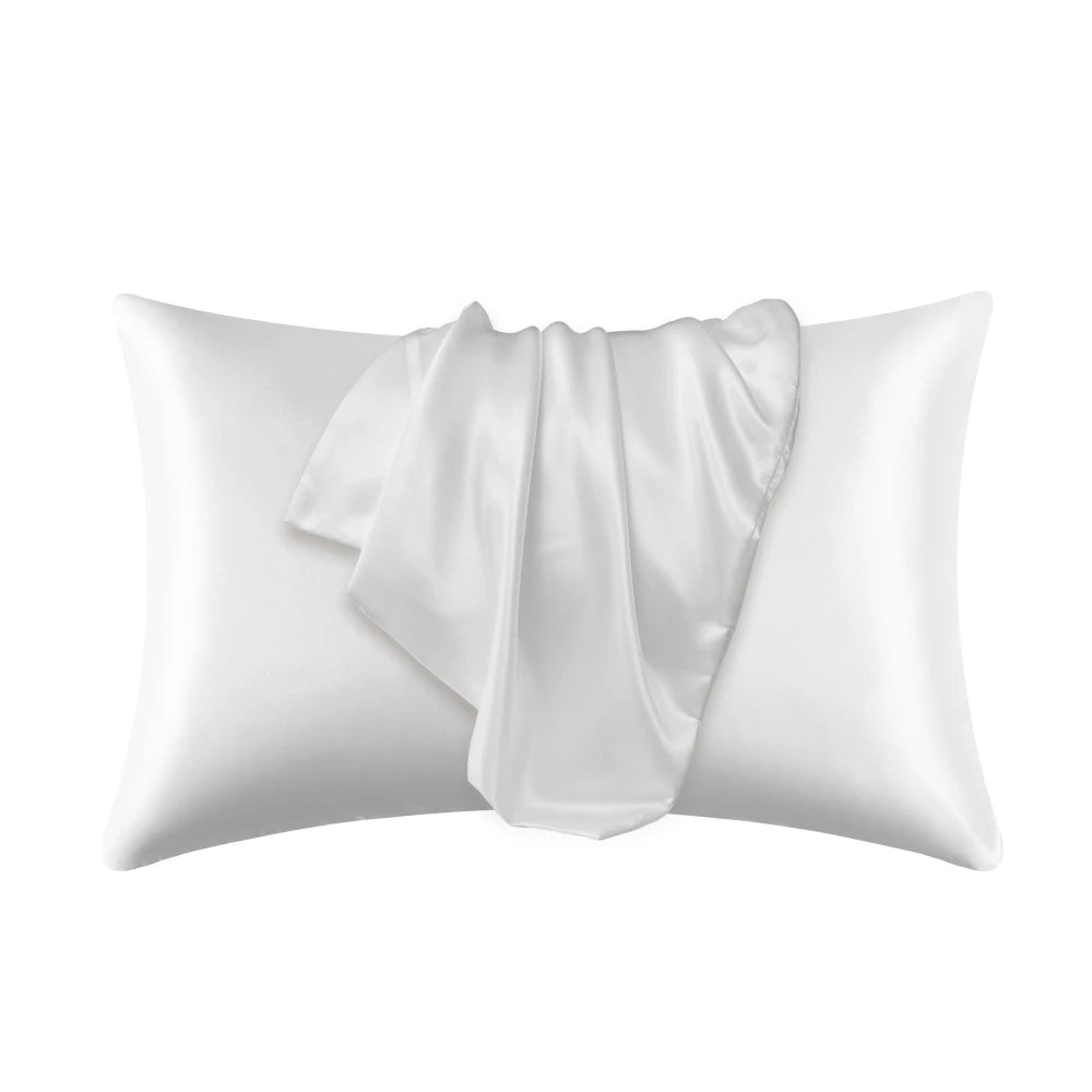 A white satin silk pillow cover is shown folded and lying on a white background.