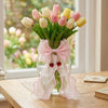 A bouquet of pink and yellow tulips tied with sheer pink ribbon bow curtain tiebacks