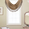 A beige window curtain valance with tassels is draped over a white-framed window.