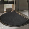 A black half-round non-slip PVC door mat with a diamond pattern placed on a tiled floor.