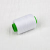 A roll of white sewing thread with a green core.