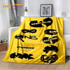 A bright yellow flannel throw blanket featuring various black stylized text designs on a white background.