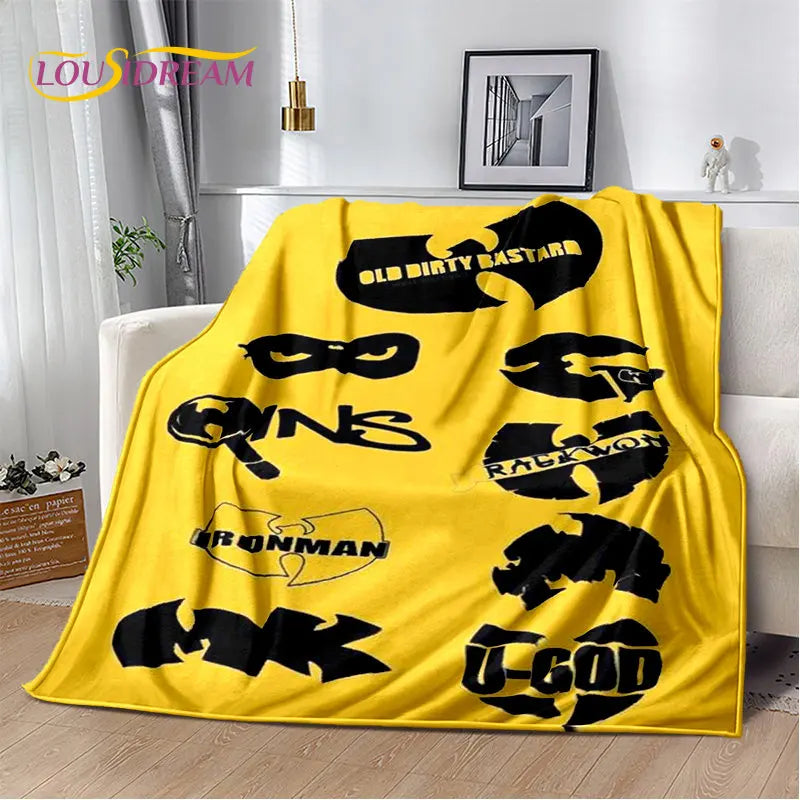 A bright yellow flannel throw blanket featuring various black stylized text designs on a white background.