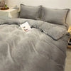 A gray luxurious flannel duvet cover set with matching pillows and a book on the bed.