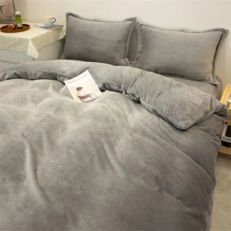 A gray luxurious flannel duvet cover set with matching pillows and a book on the bed.