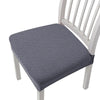 Gray removable polyester bar and dining seat covers on a white wooden chair.