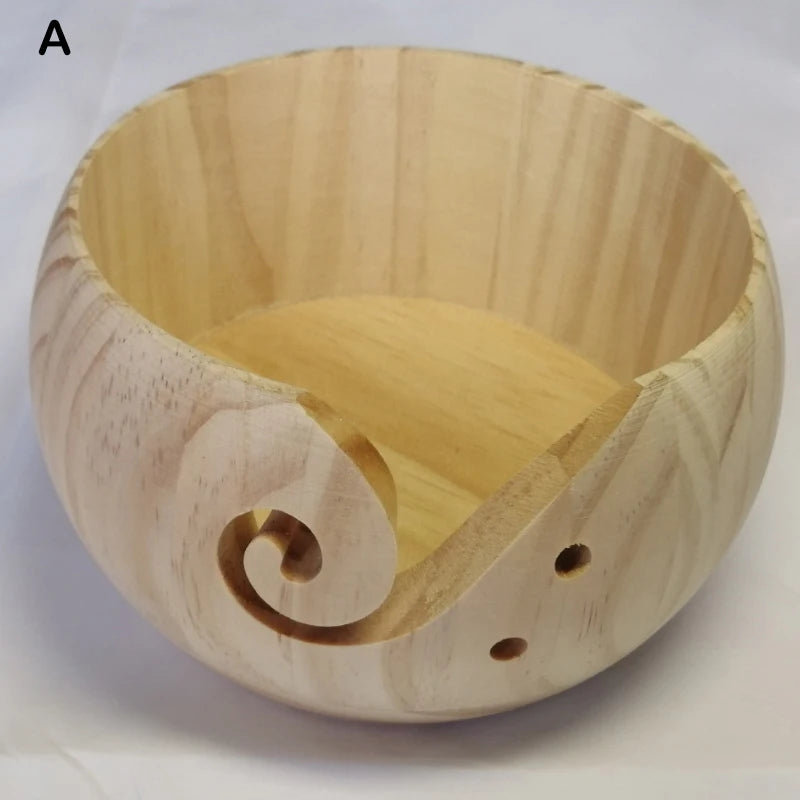 A light-colored wooden bowl with a spiral design used for yarn and fiber organization.