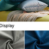 Close-up display of a soft, textured velvet throw pillow cover in shades of blue and gray.