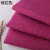 Stack of three folded magenta or pink coarse linen and cotton fabric squares