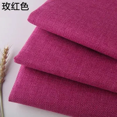 Stack of three folded magenta or pink coarse linen and cotton fabric squares