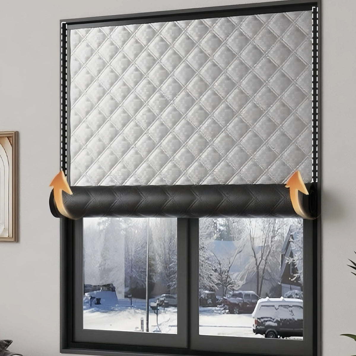 A close-up of a window with a quilted silver thermal film applied, showing an exterior winter scene.