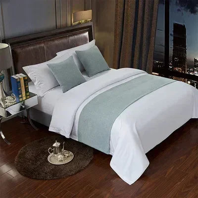 A white bed with gray bedding and decorative flags on pillows in a modern bedroom setting.