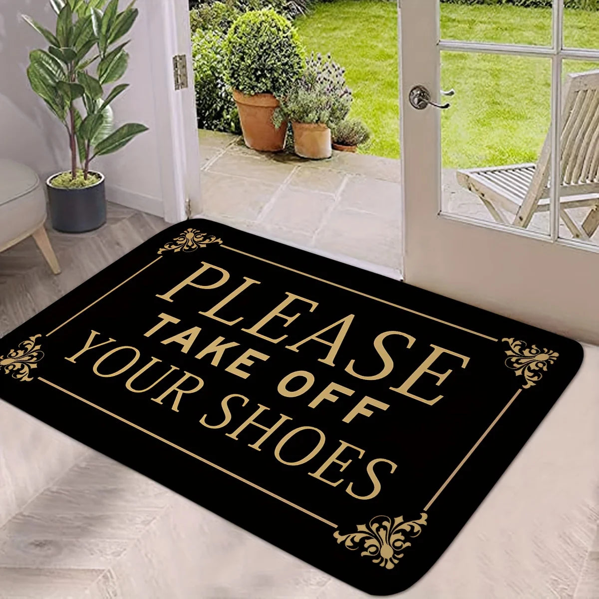 A black doormat with gold lettering that reads Please Take Off Your Shoes