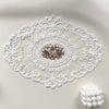 White oval lace embroidered doily used as a coaster or decorative item