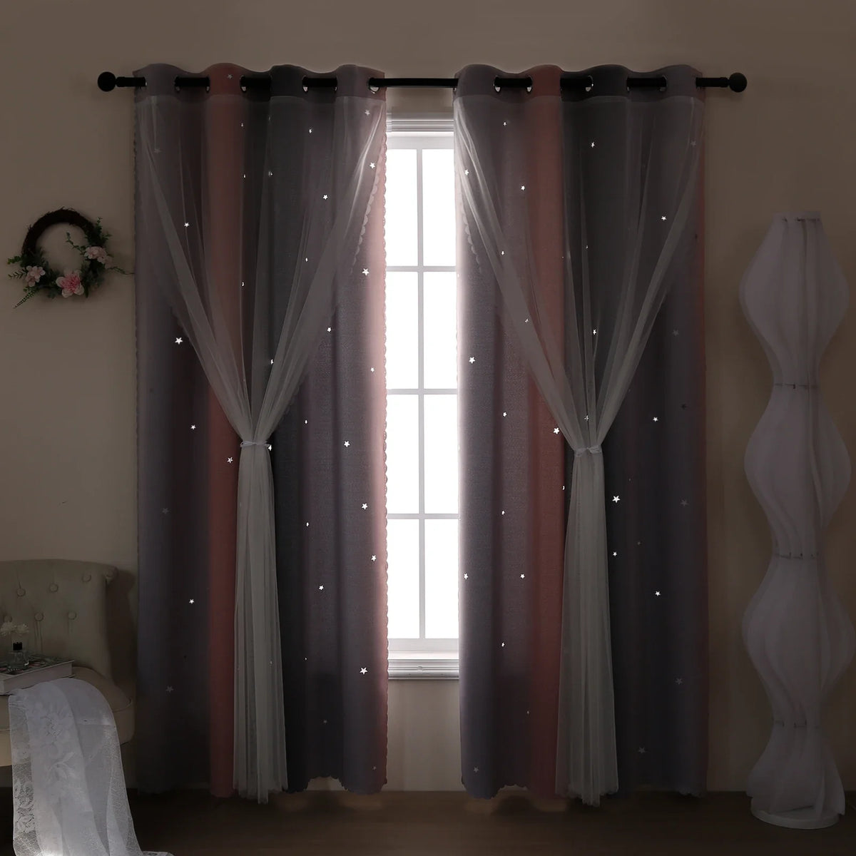 Grey and pink gradient star perforated curtains hanging in a window frame.