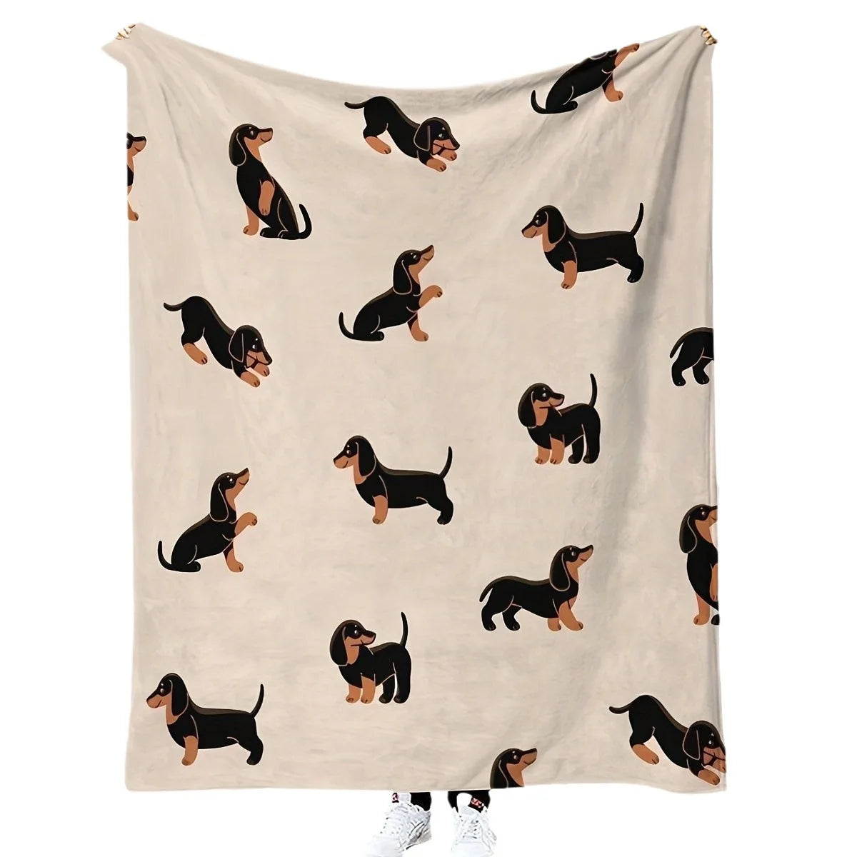 A light beige flannel blanket featuring a repeating pattern of black dachshund silhouettes.