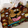 A brown cartoon dog design on a flannel throw blanket with various character illustrations.