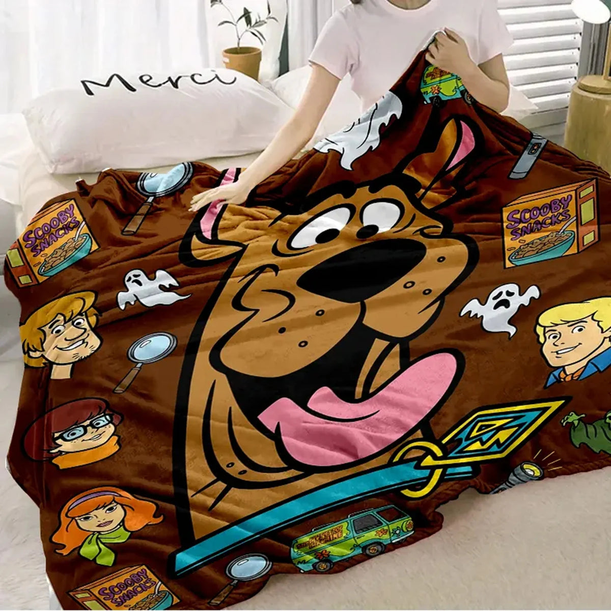 A brown cartoon dog design on a flannel throw blanket with various character illustrations.