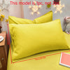 A bright yellow matte solid color pillowcase with a star-shaped light decoration on the wall.