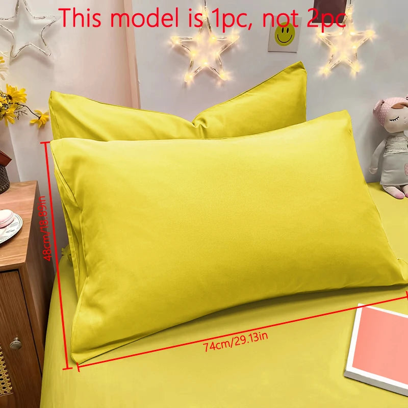 A bright yellow matte solid color pillowcase with a star-shaped light decoration on the wall.