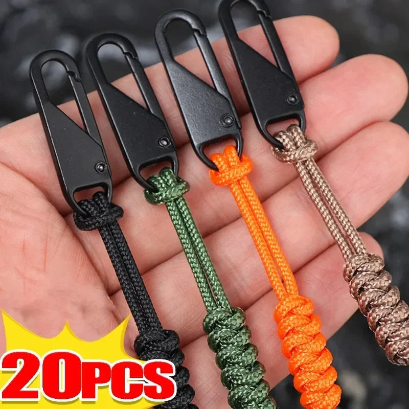Five detachable zipper pull sliders in black, green, orange, and brown are shown being held in a hand.