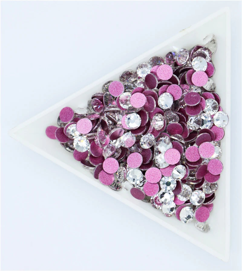 A flatback tray filled with pink and silver crystal rhinestones for crafts and decor
