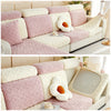 A pink and cream plush velvet sofa cover with a quilted pattern and anti-slip backing.