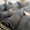 A close-up of a gray luxurious washed cotton bed linen set featuring pillows and a duvet on a bed.