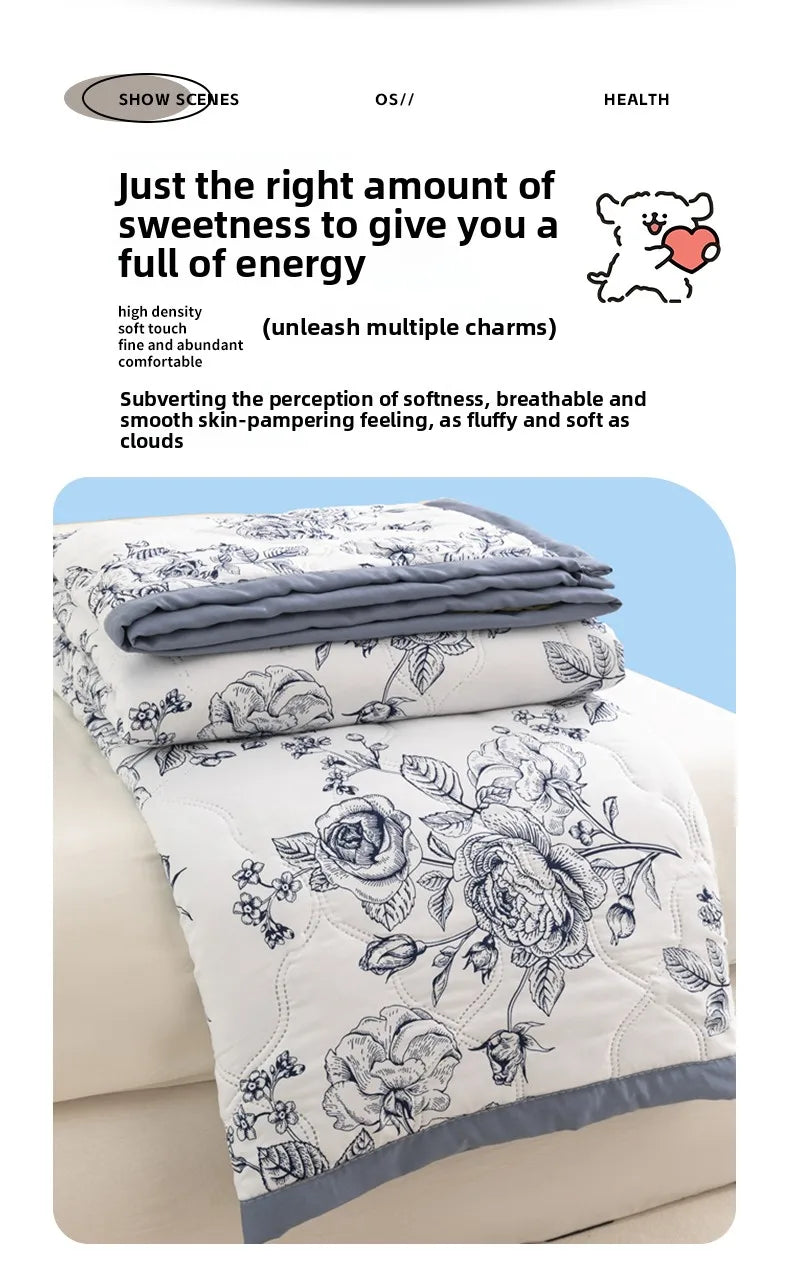 A white duvet cover featuring a floral pattern with gray accents, rolled neatly on a light-colored bed.