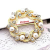 Gold-toned metal ring clips featuring pearl and diamond accents for clothing and accessories