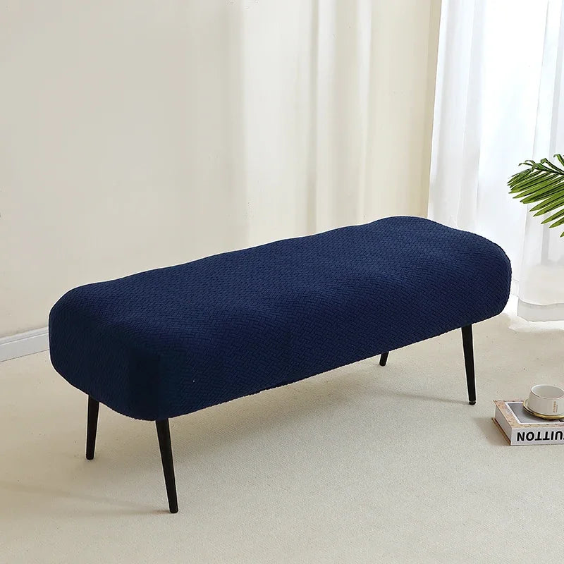 A navy blue elastic jacquard bench cover is shown on a light floor, ready for use as piano, dining, or entryway seating.