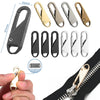 A set of metal zipper sliders and a zipper repair kit components shown against a black fabric background.