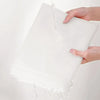 Hands are pouring water onto a white transparent garment dust cover for hanging clothes.