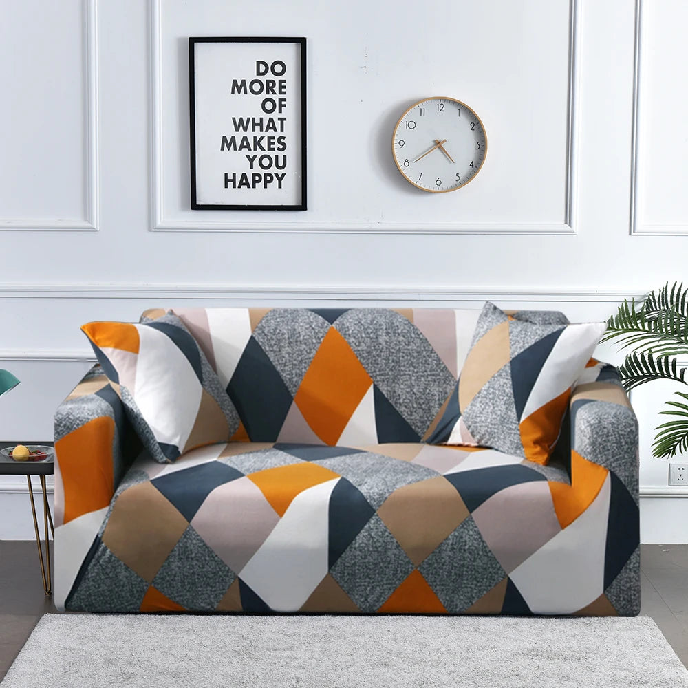 A modern sofa covered in a geometric pattern of gray, orange, and beige fabric on a light gray rug.
