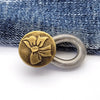A round brass button with a fabric flower design attached to a silver spring ring.