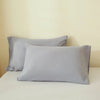 A set of two light gray luxury polyester pillow covers resting on a white surface.