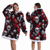 A woman models a black and red patchwork fleece hoodie with skull designs.