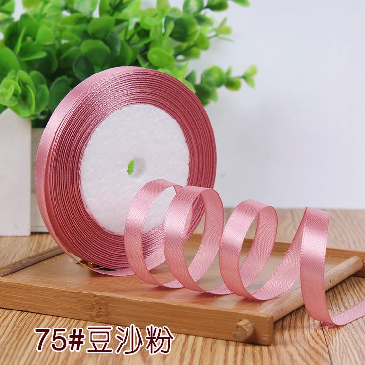 Roll of pink satin ribbon used for crafting or decoration