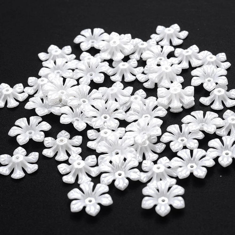 A pile of small white imitation pearl flower spacer beads for DIY jewelry