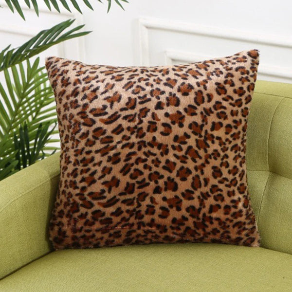 A close-up of a brown leopard print throw pillow resting on a light green sofa.