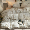 A beige plaid duvet cover set with matching pillowcases displayed on a bed.